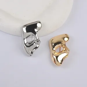 Detailed view of gold and silver vintage mask brooches featuring high-mirror finish