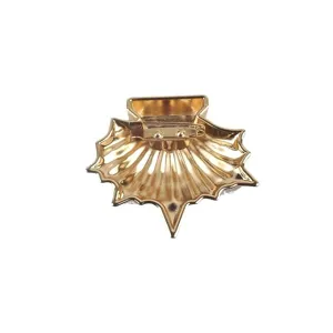 Vue arrière détaillée d'une broche en coquille dorée avec fermoir à épingle sécurisé