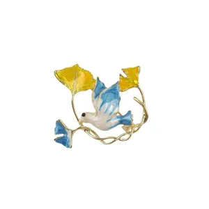 Detailansicht der Emaille-Friedenstaube-Brosche mit gelben und blauen Ginkgoblättern.