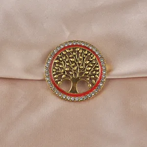 Vue détaillée d'une broche arbre de vie dorée antique avec cristaux et émail rouge