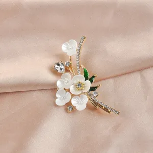 Gedetailleerd overzicht van elegante witte kristallen bloembroche op satijn