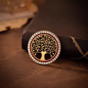 Vue macro d'une broche arbre de vie vintage en or avec des strass blancs brillants.