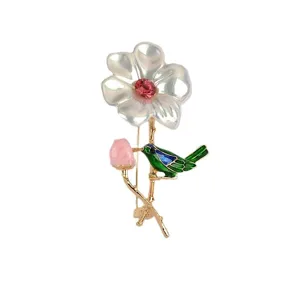 Detailopname van een elegante bloemenbroche met kristal en levendig groen vogeldetail
