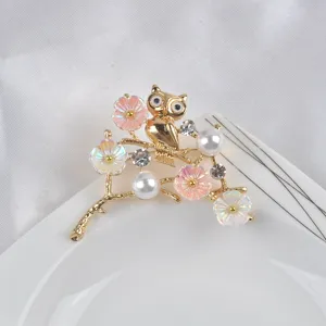 Exquisite Eulenbrosche mit floraler Emaille und Perlendetails auf einem goldenen Zweig