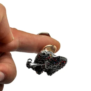 Close-up view of a sparkling rhinestone elephant magnetic brooch converter held by a finger.