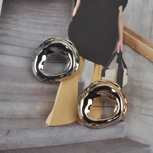 Detailed view of irregular molten metal gold and silver brooches for fashion styling