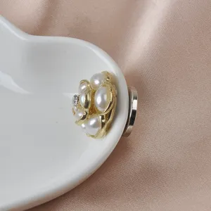 Close-up van elegante gouden magnetische broche met bloemmotief, parels en stras
