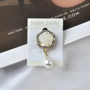 Detailopname van een elegante magnetische rozenbroche met strass en een witte parel