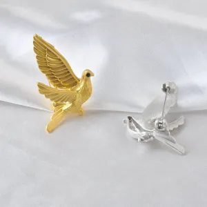 Peace dove bird brooch pins in gold and silver matte finish on white satin background