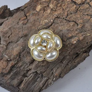 Detailopname van gouden bloem magnetische broche met parels en kristal