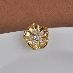 Gedetailleerde weergave van een gouden bloem magnetische broche met marquise stenen.