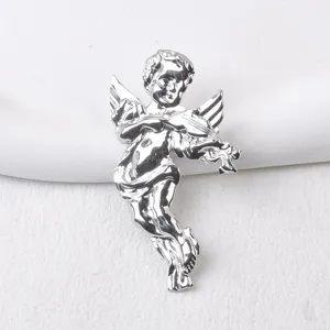 Detalle de un broche de querubín en plata pulida tocando el violín con elegancia.