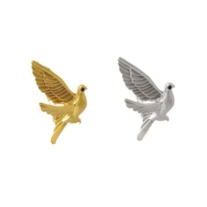Detailed view of stylized peace dove brooches in polished gold and silver metal finishes
