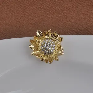 Gedetailleerde macro-opname van een gouden magnetische zonnebloemspeld met zirkonia