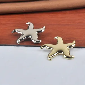 Vue détaillée de broches élégantes en forme d'étoile de mer en finitions or et argent