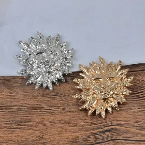 Gros plan sur des broches vintage en forme de soleil en métal fondu doré et argenté