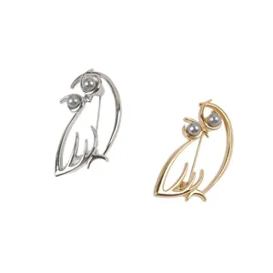 Detailaufnahme eleganter hohler Vogelbrosche in Gold und Silber mit grauen Perlen