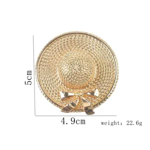 Detail view of gold straw hat brooch with intricate weave pattern and bow accent
