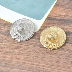 Detailed close-up of elegant gold and silver straw hat brooches with a delicate bow design