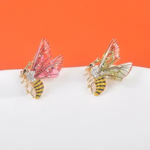 Detailansicht von kristallbesetzten Bienenbroschen mit farbigen glitzernden Harzflügeln.