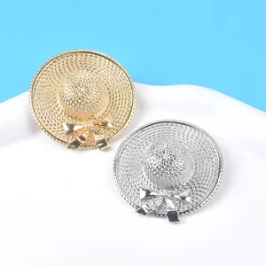 Detailed view of elegant gold and silver straw hat brooches with delicate bow tie accents.