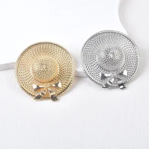 Detailed view of gold and silver sun hat brooches with woven texture and bow accent.