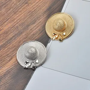 Close-up detail of stylish gold and silver straw hat brooch pins for coats and suits