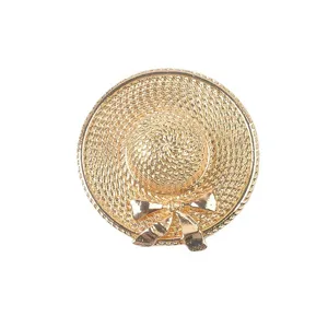 Detailed macro view of an elegant gold straw hat brooch with a bow and texture.