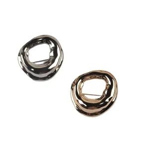 Irregular geometric circular brooch pins in gold and silver finish on white background