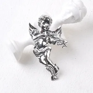 Vista detallada de un broche de ángel en plata pulida con violín sobre busto