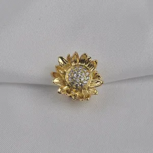 Macrodetail van een gouden bloem magnetische gesp met fonkelende zirkonia kristallen.