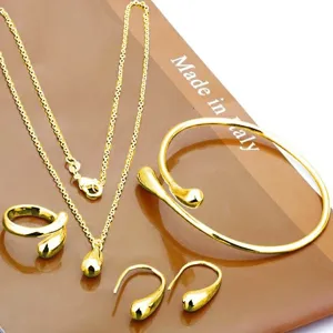 Detail van gouden druppel sieradenset met elegante ketting, armband, ring en mooie oorbellen.