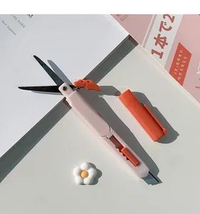 Vue de détail de couteau utilitaire et ciseaux stylo 2-en-1 portable, outil de papeterie créatif.
