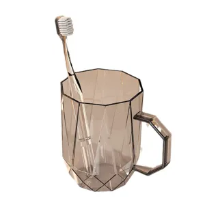 Transparante geometrische tandenborstelbeker met handvat en tandenborstel voor de badkamer.