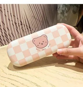 Detailed view of portable plaid glasses case with cute cartoon bear pattern, durable storage.