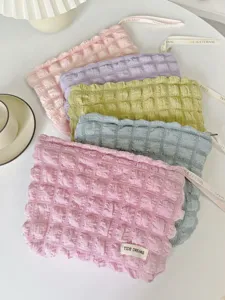 Pochette de maquillage douce effet nuage bulle froissé, détail de trousse de voyage portable.