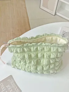Détail de trousse de maquillage matelassée, pochette de voyage douce avec fermeture éclair.