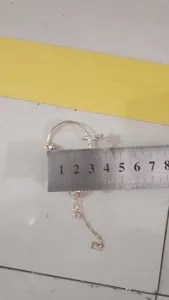 Orecchino a clip con fiore strass e nappa dettaglio, elegante gioiello da orecchio.