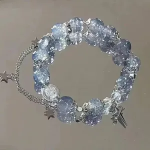 Detailed view of the stylish glass bead bracelet featuring cute metal star charms and chain.