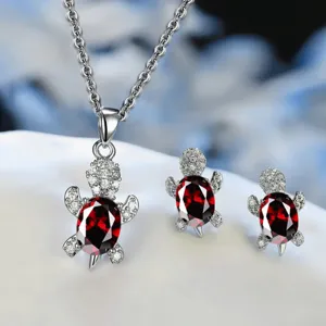 Hermoso juego de joyas con collar y aretes en forma de tortuga con circonitas rojas.