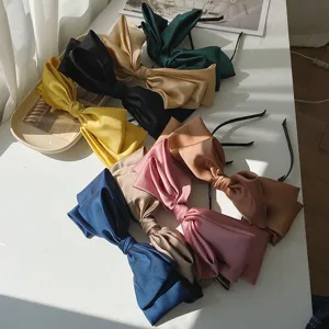 Assorted colors of oversized satin bow headbands for elegant and chic hair styling.