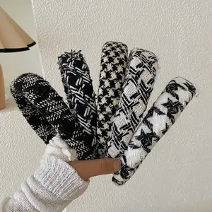 Détail de cinq serre-têtes larges en tricot à motifs pied-de-poule noir et blanc.