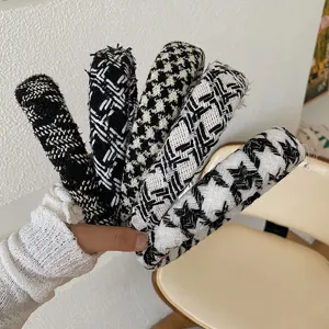 Détail de cinq serre-têtes élégants en tweed et pied-de-poule, en tricot noir et blanc chic