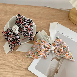 Close-up detail showing floral bow hair ties with elegant ribbons and pearl charms