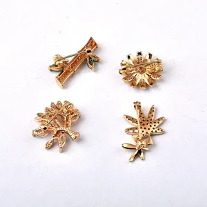Primer plano de cuatro elegantes broches de metal dorado con cierres traseros seguros