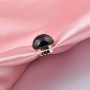 Black round magnetic anti-exposure brooch for clothes on pink silk fabric background