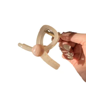 Pince à cheveux élégante en résine beige avec perle marbrée pour coiffure féminine.