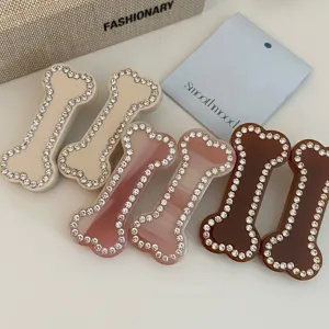 Détail des barrettes en forme d'os ornées de strass étincelants dans un style Y2K tendance.