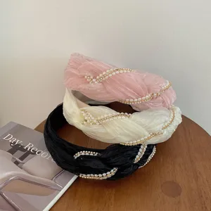 Primo piano di cerchietti in tessuto plissettato con perle e strass eleganti