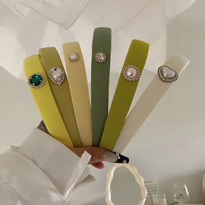Detail view of various green padded headbands decorated with heart and pearl rhinestones